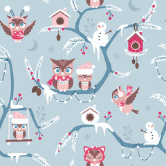 Seamless surface repeat vector pattern with little brown owls in red and pink winter clothes on blue branches covered with snow on a blue background