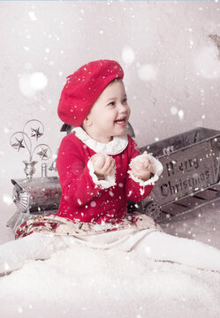 Ni&ntilde;a vestida de rojo con un tren de navidad y nieve