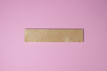 Wooden plank on a pink background. Colored background. Background for design, lettering or logo.