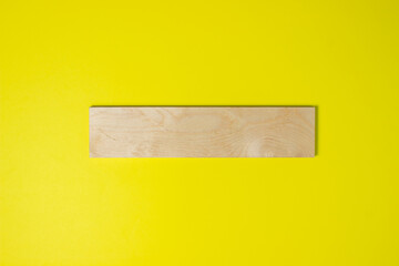 Wooden plank on a yellow background. Colored background. Background for design, lettering or logo.