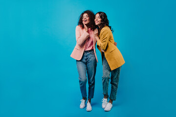 Full length portrait of two women enjoying conversation. Studio shot of pretty girls talking on...