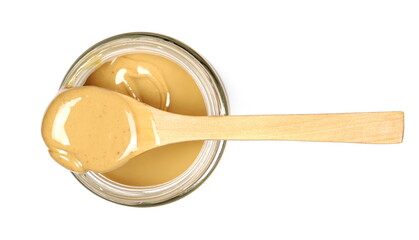 Peanut butter in glass jar with wooden spoon isolated on white background, top view