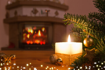 Christmas background with burning candle, fireplace and decorated Christmas tree