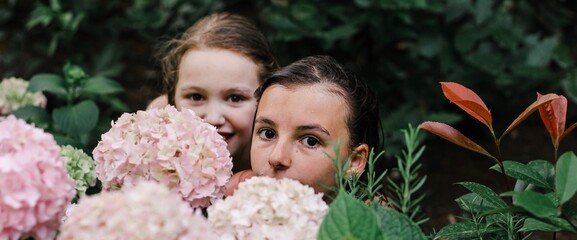 Portrait of a girl with a friend among tropical flowers and plants. Vacation, summer, holidays, nature banner.	