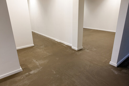 An empty new room with a new clean concrete floor, ready to be painted or made into a synthetic cast floor installation.