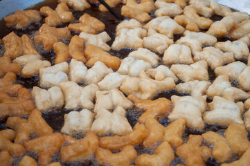 Patongo snacks that are being fried in a pan of boiling oil.
