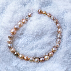 Luxury elegant baroque pearl bracelet on white snow background