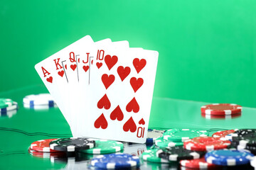 Royal Flush combination under the water drops against green background. Online gambling. Betting. Gambling addiction.