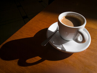 Taza de café y plato en una mesa de cafetería.