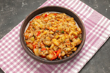 bottom view roasted eggplant salad in bowl on napkin on dark background