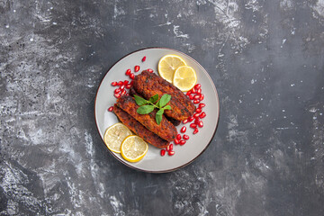 Fototapeta na wymiar top view meat cutlets long formed with lemon slices on a grey background meal photo dish