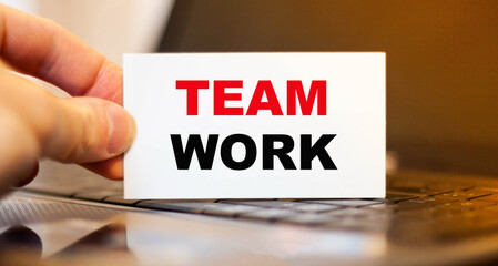 Fototapeta premium A man holding a business card with a TEAM WORK proposal