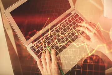 Double exposure of woman hands working on computer and forex chart hologram drawing. Top View. Financial analysis concept.