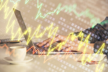 Double exposure of businesswoman hands typing on computer and forex graph hologram drawing....