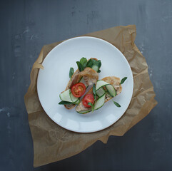 
two bruschetta with bacon, cucumber and herbs