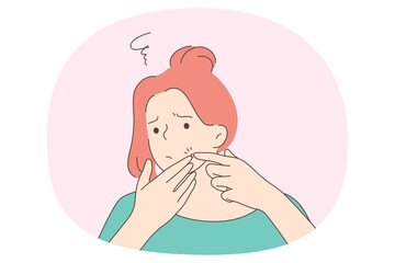 Squeezing pimples concept. Young unhappy frustrated girl standing trying to squeeze red acne spot pimple on her face. Problem skin dermatology concept 