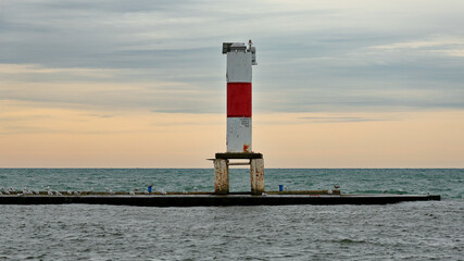 Lighthouse on breakwater with seagulls