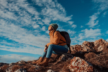 Naklejka na ściany i meble Freedom traveler woman sitting on the top of mountains and enjoy a wonderful nature. Yound girl on peak mountain with perfect view snowy mountains. travel concept