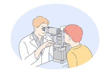 Doctor, medicine, ophthalmologist concept. Young smiling man doctor optometrist examining eyes of little boy patient with special equipment in medical clinic. Medicare, therapist, healthcare 