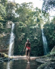 Woman in bikini at tropical waterfall in Lombok Indonesia