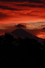 This photo is of a silhouette of Mount Slamet and a beautiful orange sunset.
