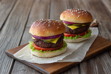 Burgers with meat, tomato, cucumber, cheese and onion. American cuisine. Fast food.