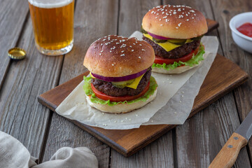 Burgers with meat, tomato, cucumber, cheese and onion. American cuisine. Fast food.