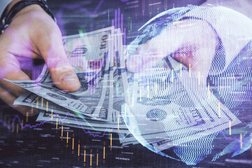 Multi exposure of financial graph drawing hologram and USA dollars bills and man hands. Analysis...