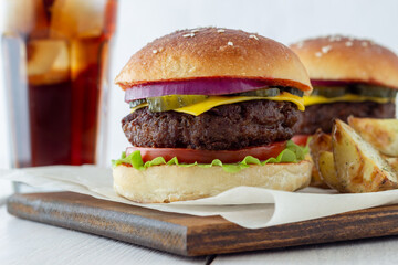 Burgers with meat, tomato, cucumber, cheese and onion. American cuisine. Fast food.