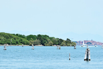 Fototapeta na wymiar Poveglia, a small island located between Venice and Lido in the Venetian Lagoon, Italy, as seen from Malamocco on Lido Island. It was used as a quarantine station in history.