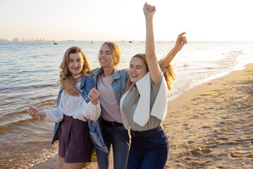 Three friends having fun on the beach, meeting friends. Young women