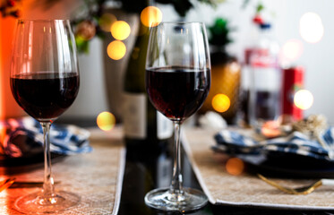 Glass of red wine and Christmas lights background.	