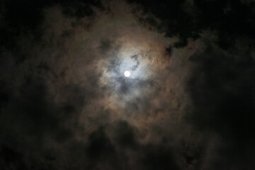 Obraz na płótnie Canvas Full moon hidden in thin clouds