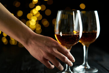 Two glasses of sparkling wine or champagne to celebrate New Year, Merry Christmas, Party or Anniversary with a yellow bokeh effect on dark background. 