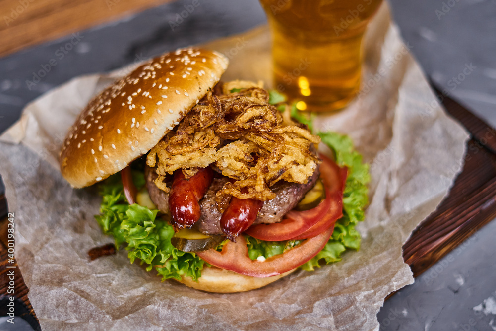 Wall mural delicious burger with sausages and beer on a wooden board