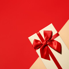 White present with red ribbon on the bright red background