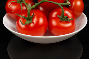 large red tomatoes in a white dish