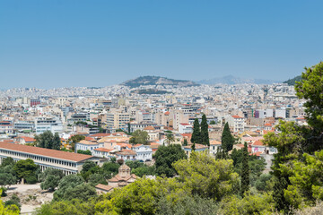 Fototapeta na wymiar Aerial view of cityscape near Acropolis with crowded buildings of Athens with Stoa of Attalos in a sunny day, view from Greece Areopagus Hill