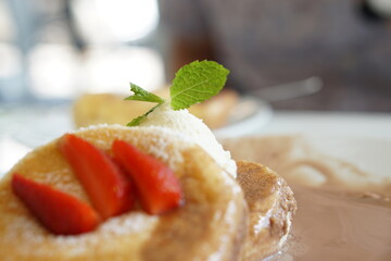Close of mint leaves topping on Fluffy pancake with Chocolate nuts sauce.