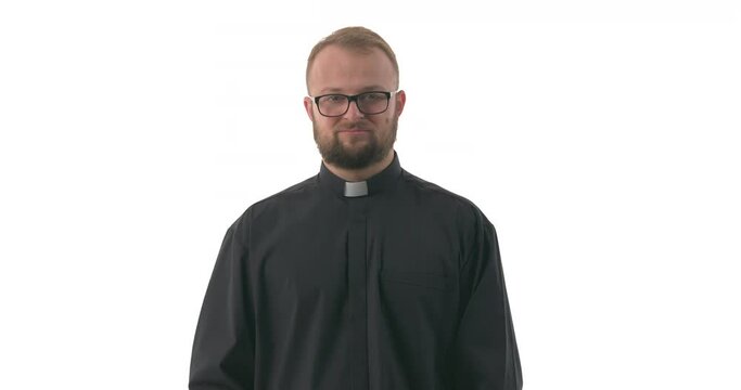 Young Caucasian priest expressing disdain and arrogance as is if pushing something unpleasant away by hand. Shoo gesture. Body language. Isolated on white background