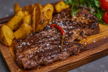 Beef steak with hot chili pepper on a wooden board