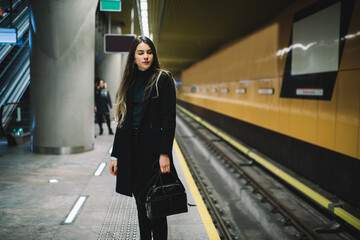 Calm young woman in casual outfit at subway platform