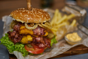  delicious burger with double cutlet and French fries on a wooden board