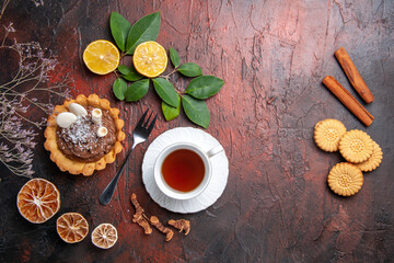 top view cup of tea with delicious little cake on dark desk dessert biscuit cookie