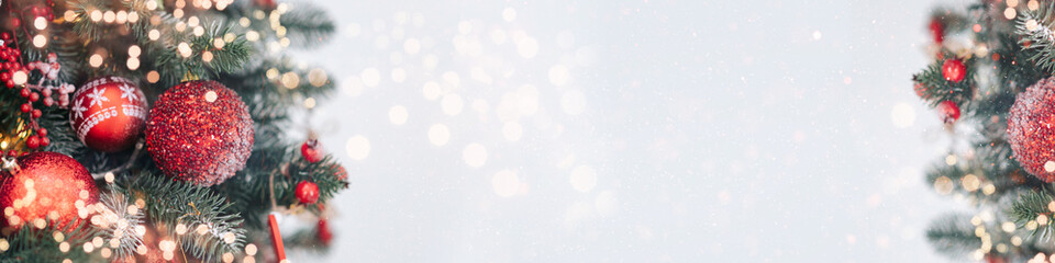 Closeup of Decorated Christmas tree on blurred, sparkling and fairy light background. Happy Holidays. Happy New Year and Xmas greeting card. Copyspace, selective focus.