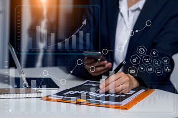 Business hands using tablet and smart phone with analyzing sales data and economic growth graph...