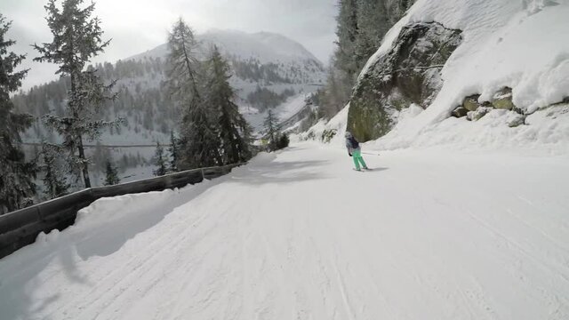Female skier makes a carve on the ski slope downhill - Slow motion