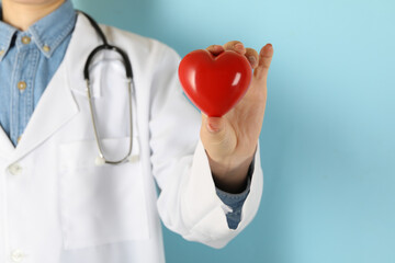 Female doctor with stethoscope holding red heart