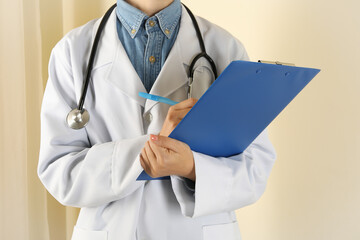 Female doctor with stethoscope holding clipboard and pencil