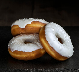 donuts sprinkled with powdered sugar on a dark background